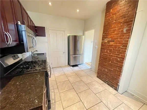 a kitchen with stainless steel appliances granite countertop a refrigerator and a stove