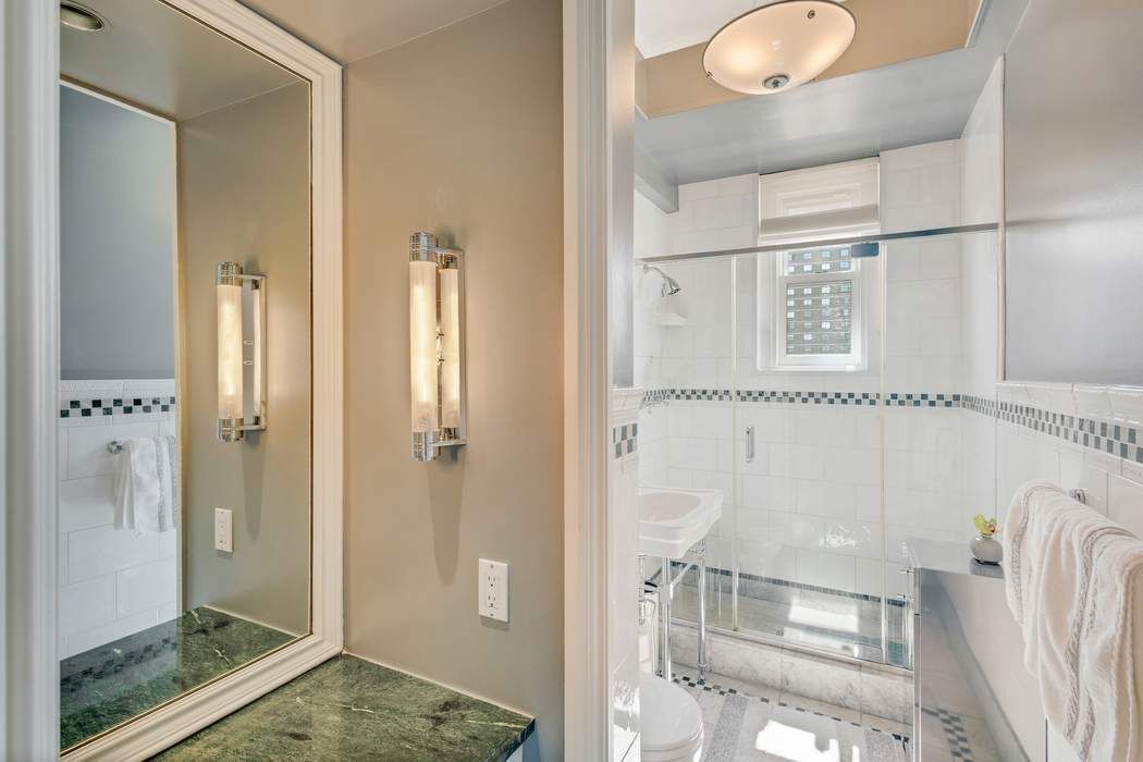 139 East 94th Street, Unit 11CD Manhattan, NY 10128 - Photo 20 of 28 a bathroom with a glass shower door