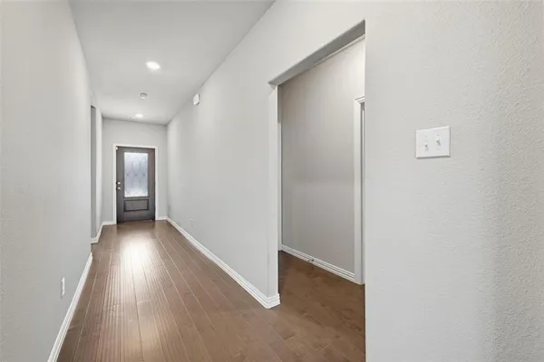 an empty room with wooden floor and a fireplace