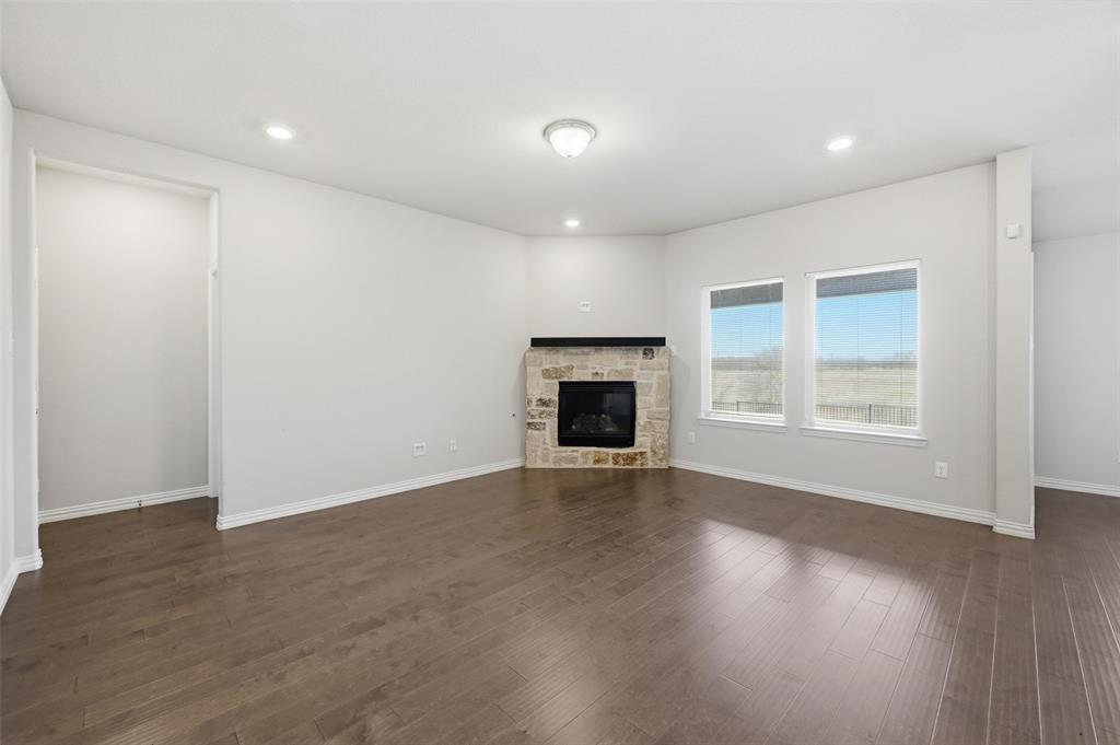 1116 Rountree Court Celina, TX 75009 - Photo 13 of 29 an empty room with wooden floor and a fireplace