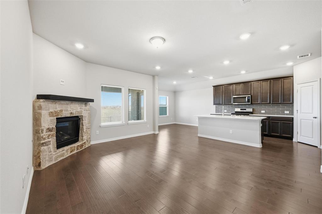 1116 Rountree Court Celina, TX 75009 - Photo 15 of 29 a view of an empty room with kitchen and fireplace