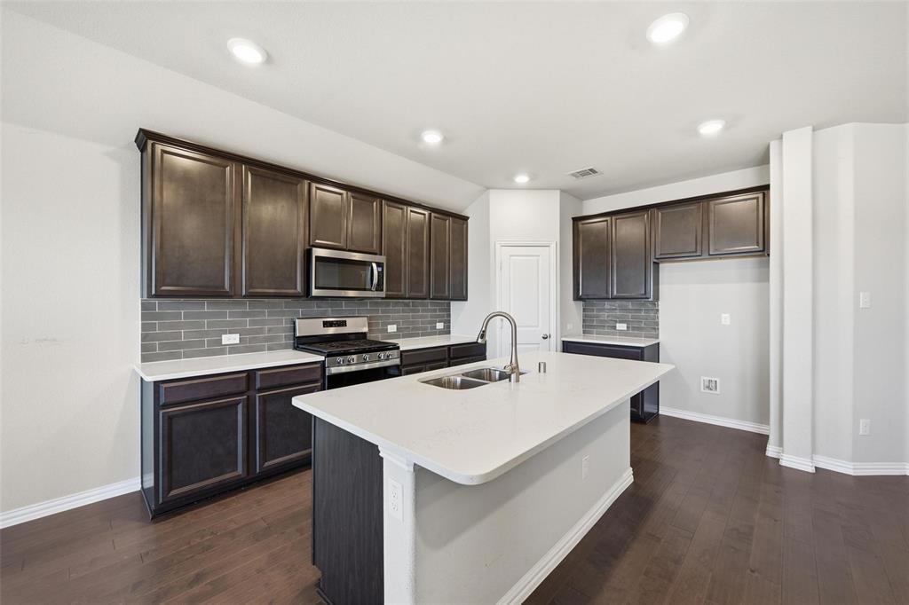 1116 Rountree Court Celina, TX 75009 - Photo 17 of 29 a kitchen that has a sink a stove and refrigerator