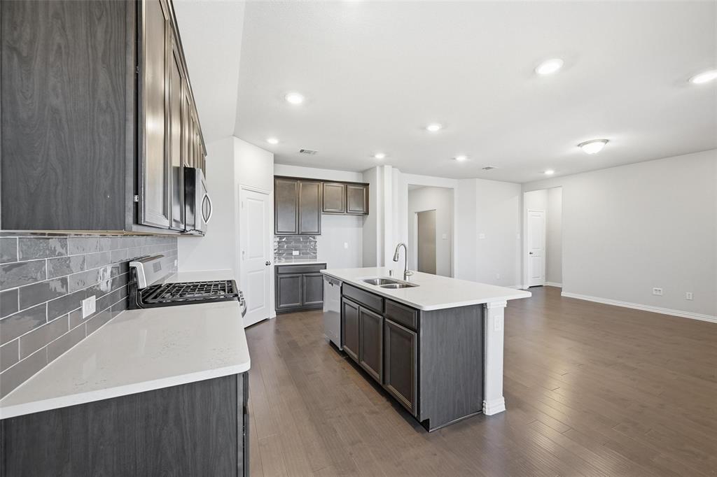 1116 Rountree Court Celina, TX 75009 - Photo 19 of 29 a kitchen with a sink stove top oven and cabinets