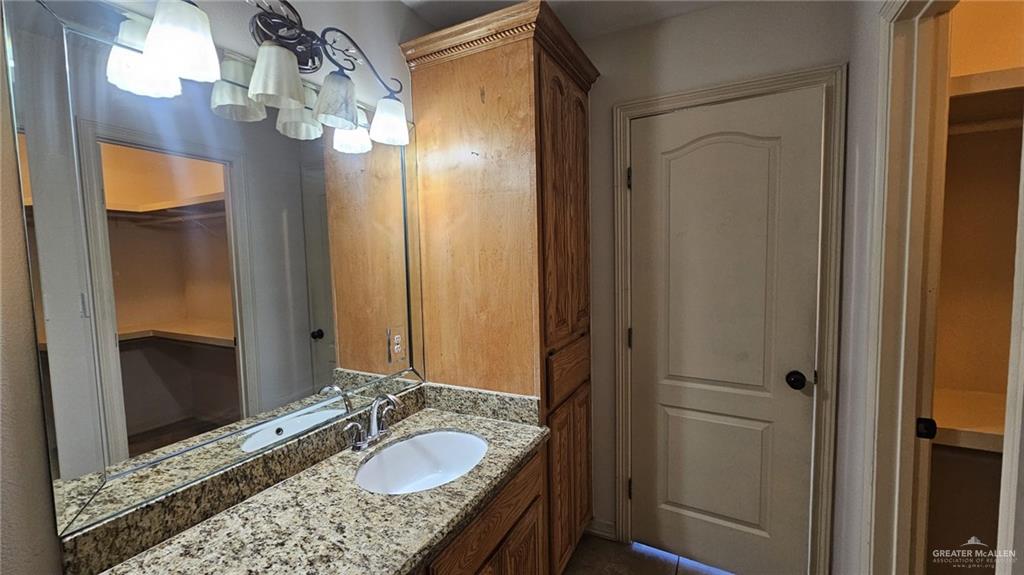 1004 West F Street Mission, TX 78572 - Photo 7 of 12 a bathroom with a granite countertop sink and a mirror