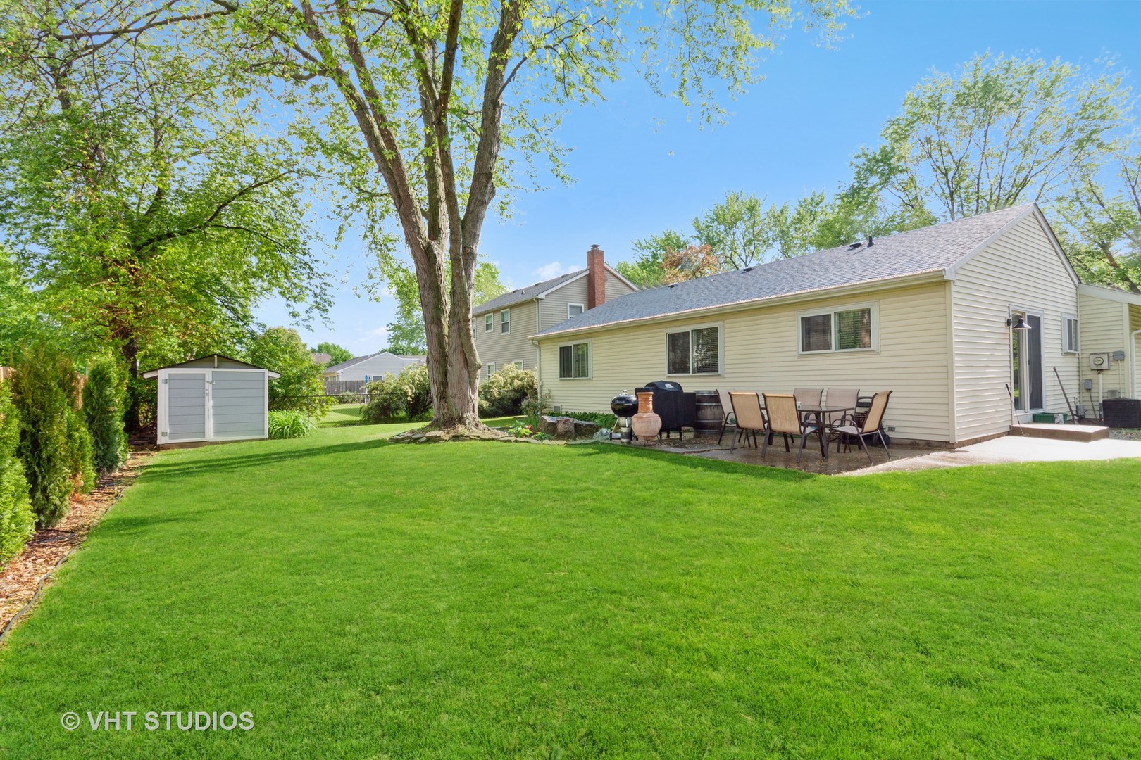 105 Cedarbrook Road Naperville, IL 60565 - Photo 10 of 11 a view of a backyard with table and chairs potted plants and large tree