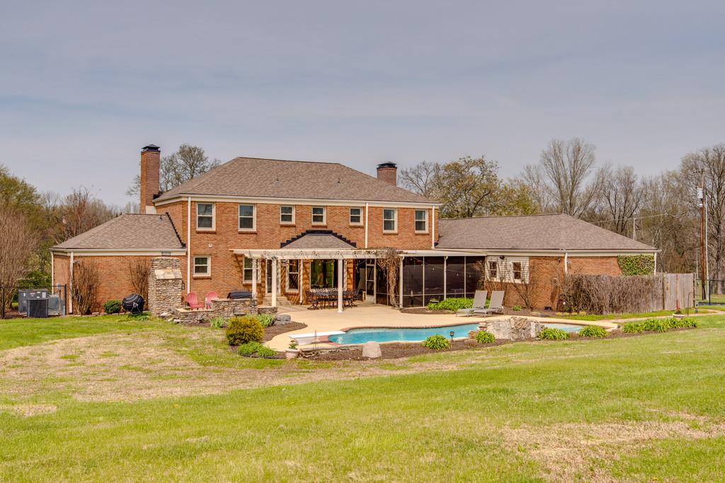891 Sneed Road West Franklin, TN 37069 - Photo 22 of 30 a front view of a house with swimming pool that has a lawn chairs and plants
