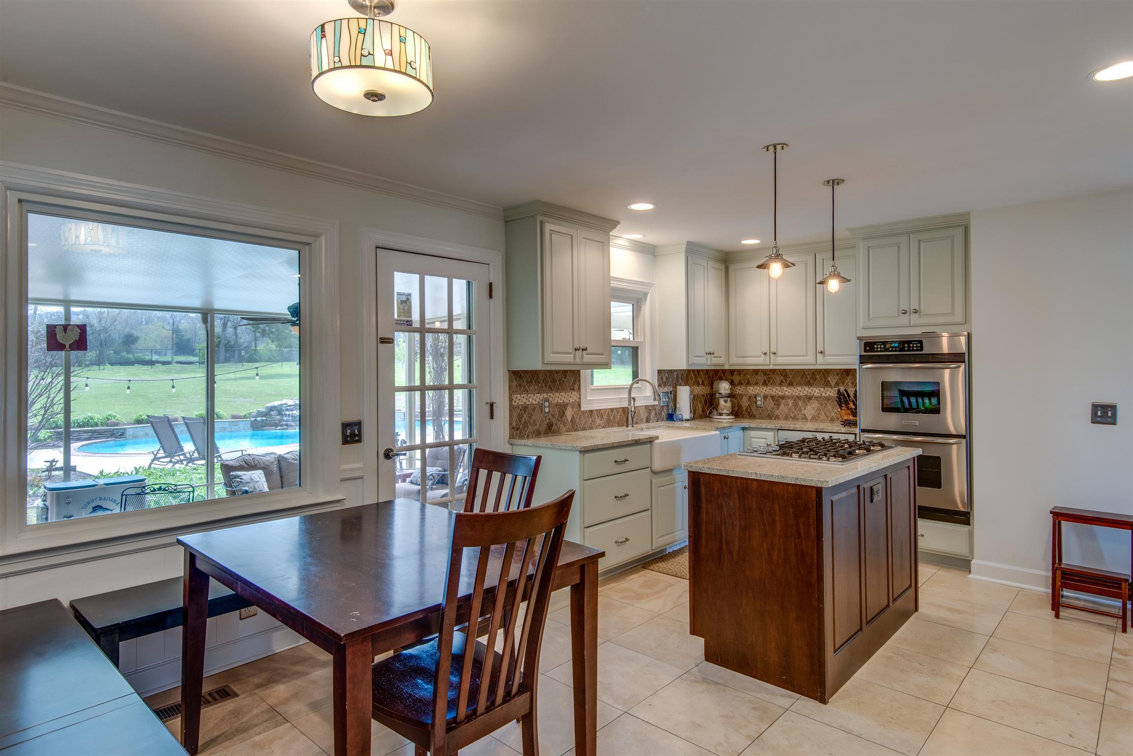 891 Sneed Road West Franklin, TN 37069 - Photo 9 of 30 a kitchen with a stove a sink a counter space and dining table