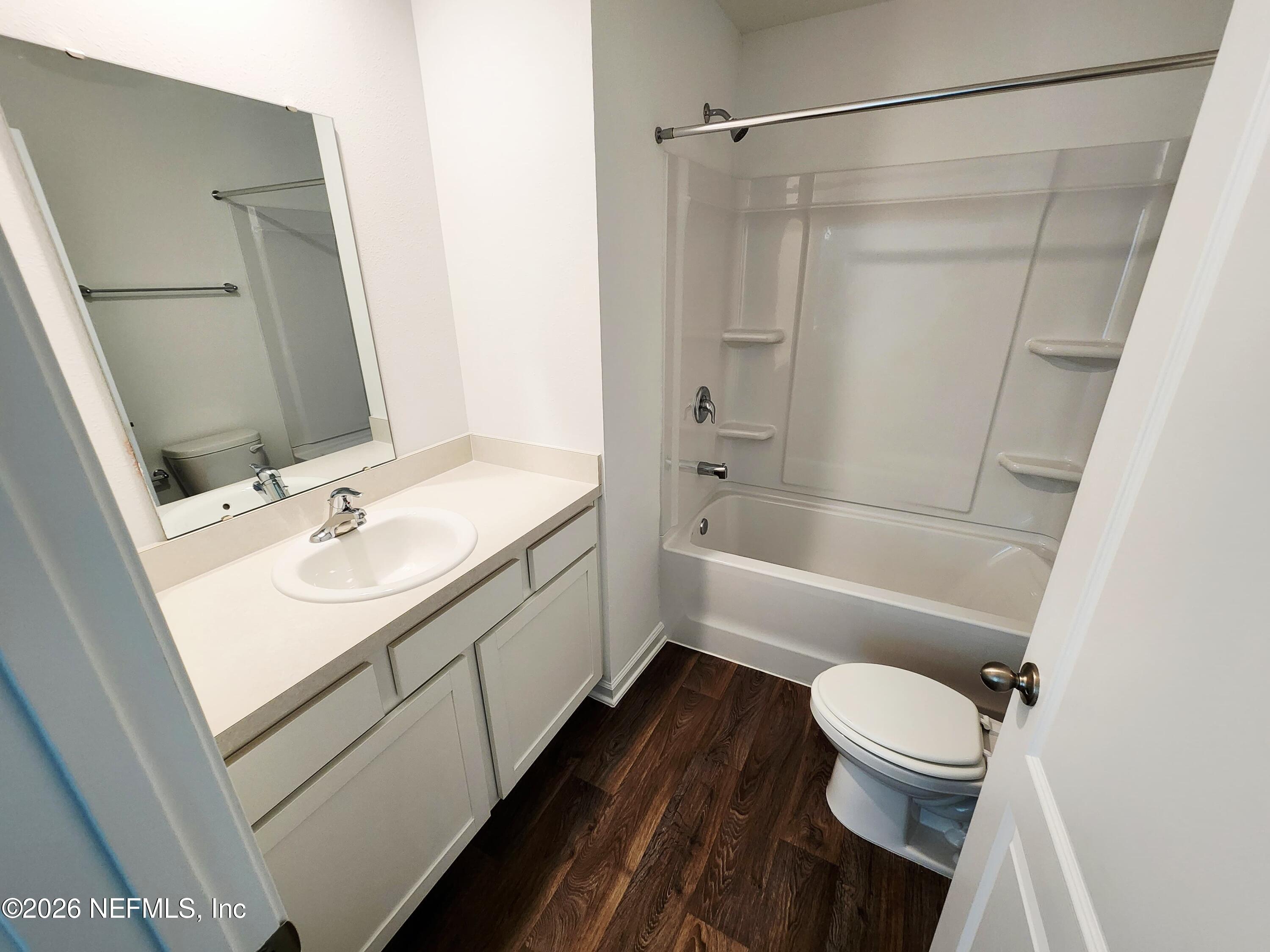 51 Palmetto Rdg Road St. Augustine, FL 32095 - Photo 14 of 16 a bathroom with a sink a toilet a mirror a bathtub and shower