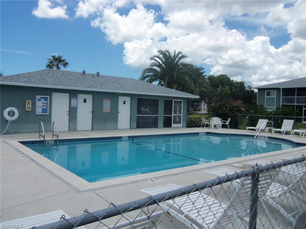 144 Cypress Way East, Unit 702 Naples, FL 34110 - Photo 13 of 18 a view of a house with swimming pool and sitting area