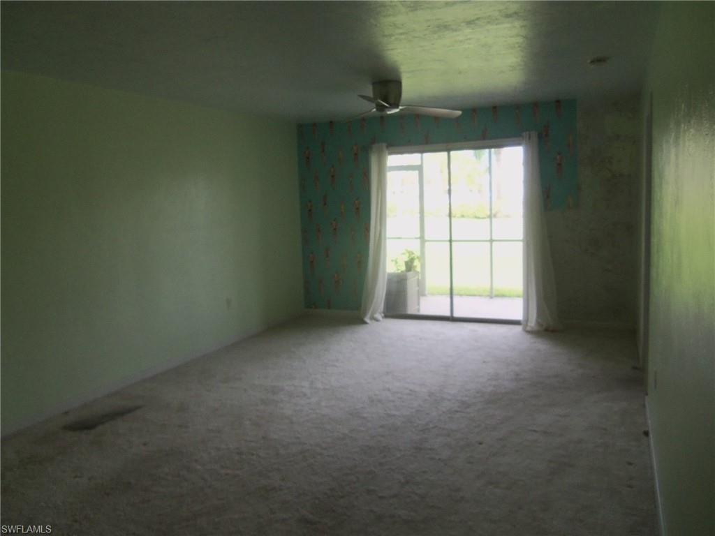 144 Cypress Way East, Unit 702 Naples, FL 34110 - Photo 4 of 18 an empty room with windows