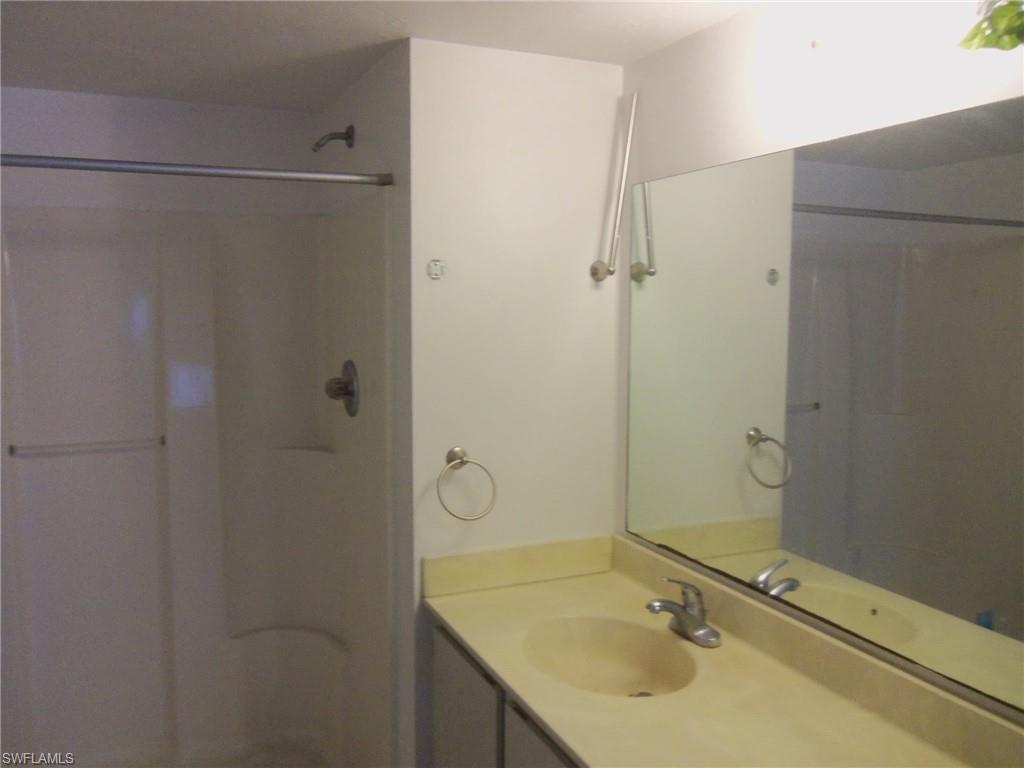 144 Cypress Way East, Unit 702 Naples, FL 34110 - Photo 6 of 18 a bathroom with a shower and a sink