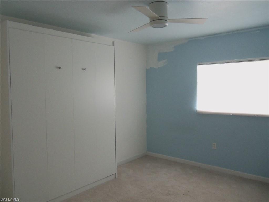 144 Cypress Way East, Unit 702 Naples, FL 34110 - Photo 7 of 18 an empty room with windows
