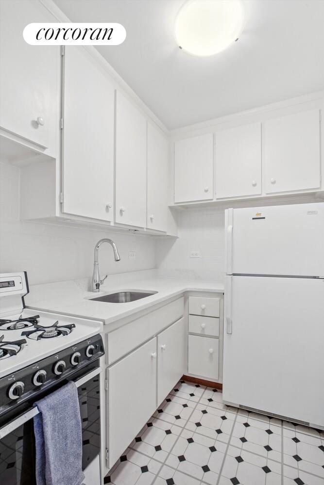 345 East 69th Street, Unit 11A Manhattan, NY 10021 - Photo 4 of 6 a kitchen with a sink stove and cabinets