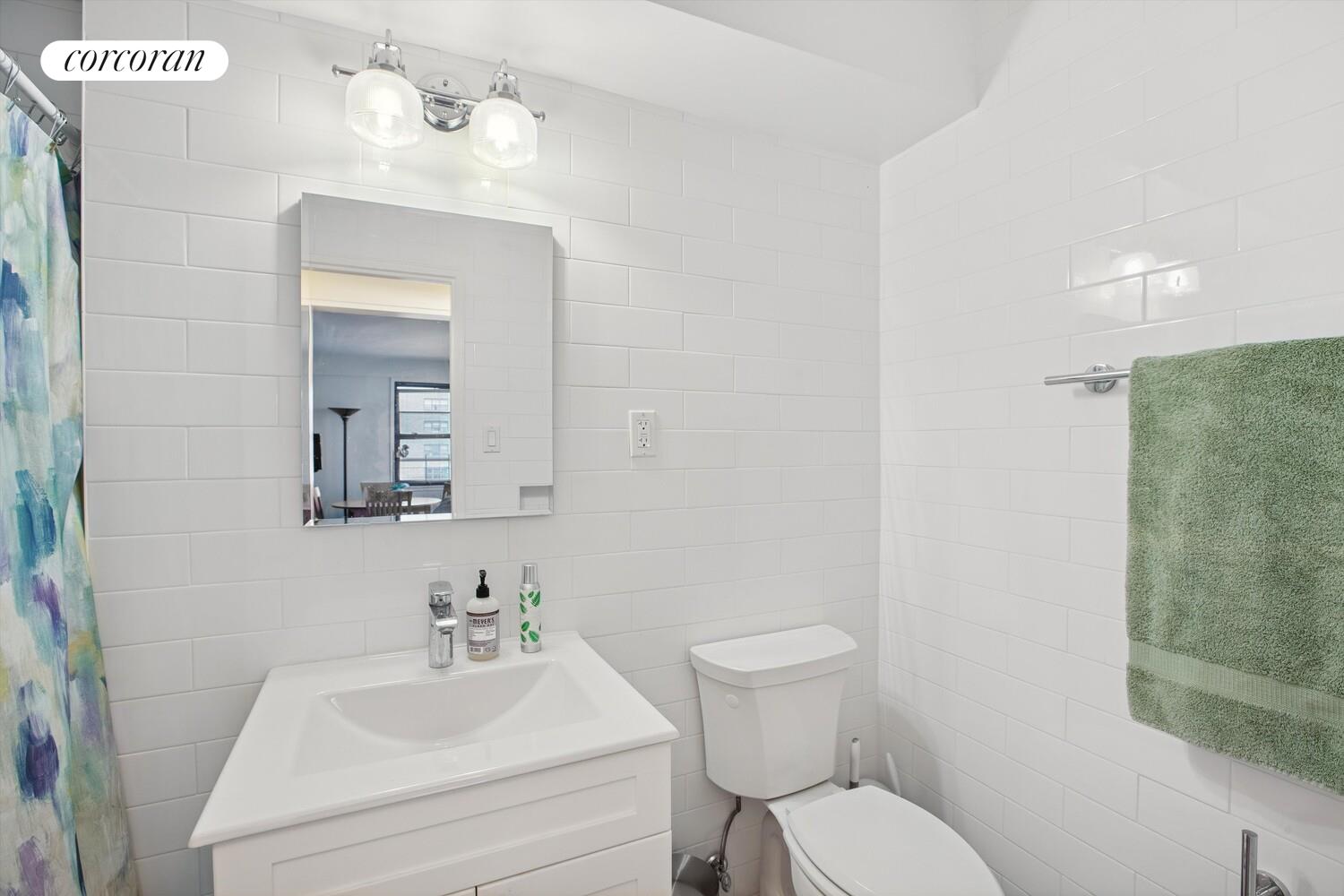 345 East 69th Street, Unit 11A Manhattan, NY 10021 - Photo 5 of 6 a bathroom with a sink mirror and toilet