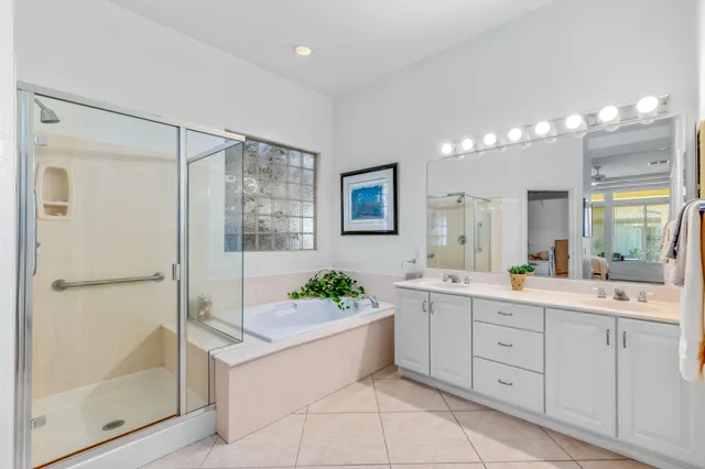 a bathroom with a tub shower and a mirror
