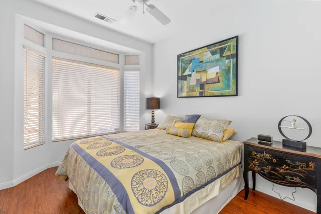 a bedroom with a bed and a painting on the wall