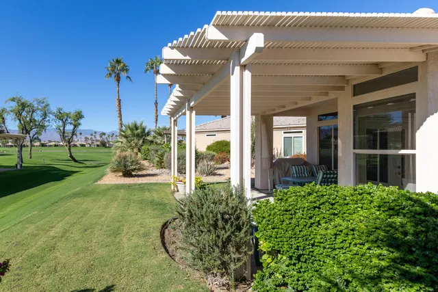a view of a patio with table and chairs potted plants with wooden floor and fence