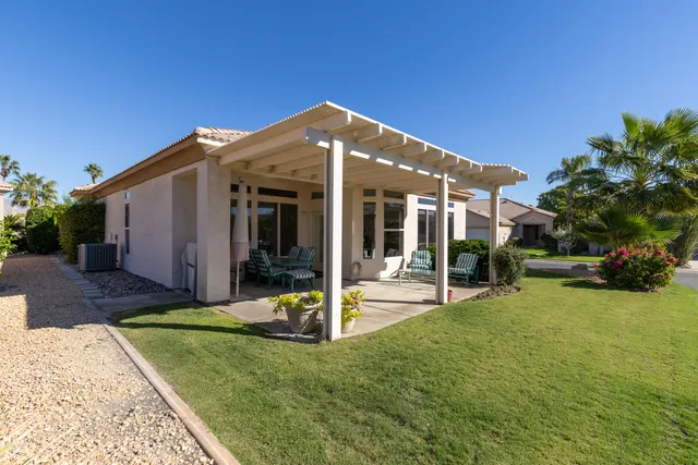 an aerial view of a house with garden space and a patio