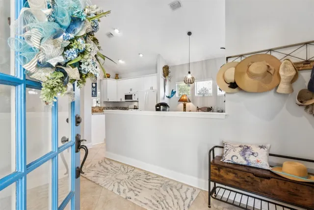 a kitchen with granite countertop a sink stove a refrigerator and white cabinets with wooden floor