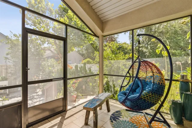 a backyard with potted plants and a large tree