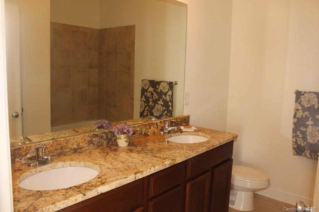 1000 East Woodlawn Road, Unit 405 Charlotte, NC 28209 - Photo 9 of 15 a bathroom with a granite countertop sink and a mirror