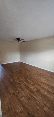 an empty room with wooden floor and cabinet