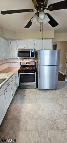 a kitchen with stainless steel appliances a stove a refrigerator and cabinets