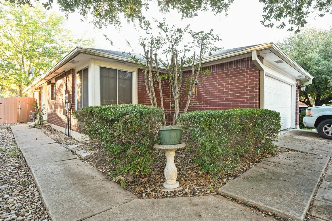 a front view of a house with a yard and potted plants