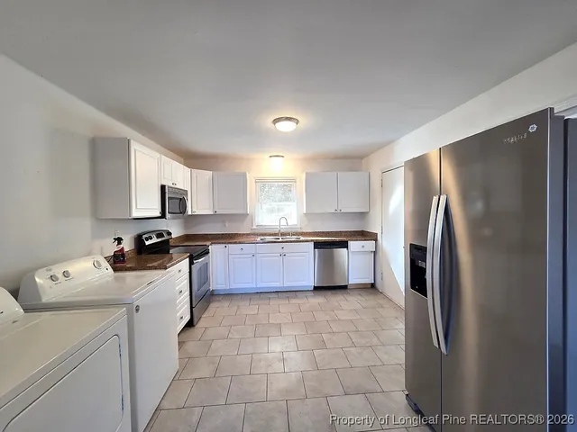 a kitchen with a refrigerator sink and cabinets