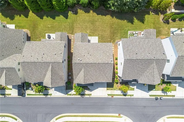 an aerial view of residential houses with outdoor space and parking