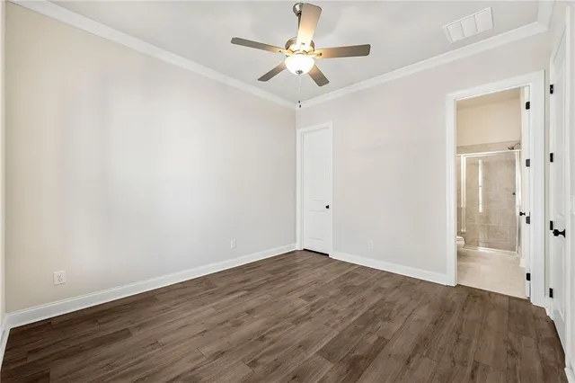 a view of a room with wooden floor and a ceiling fan