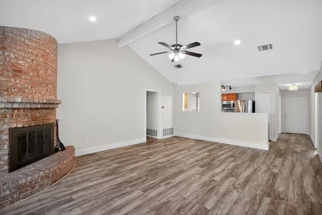 a view of empty room with wooden floor and fireplace