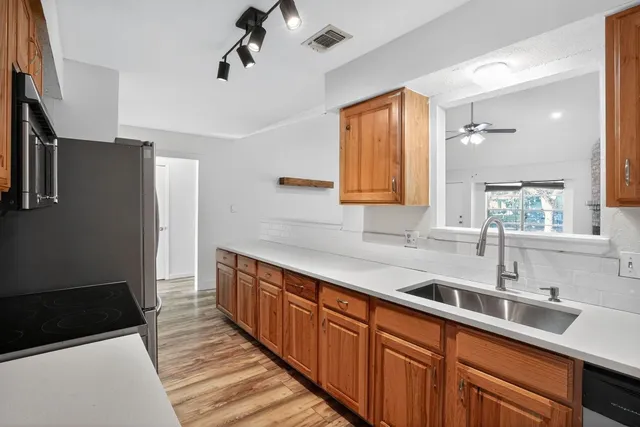 a kitchen with stainless steel appliances a sink stove and refrigerator