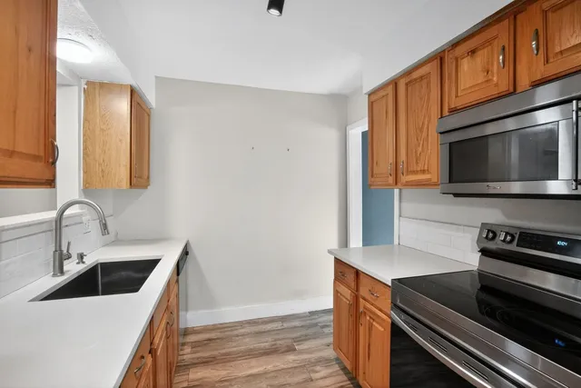 a kitchen with granite countertop a sink and steel appliances