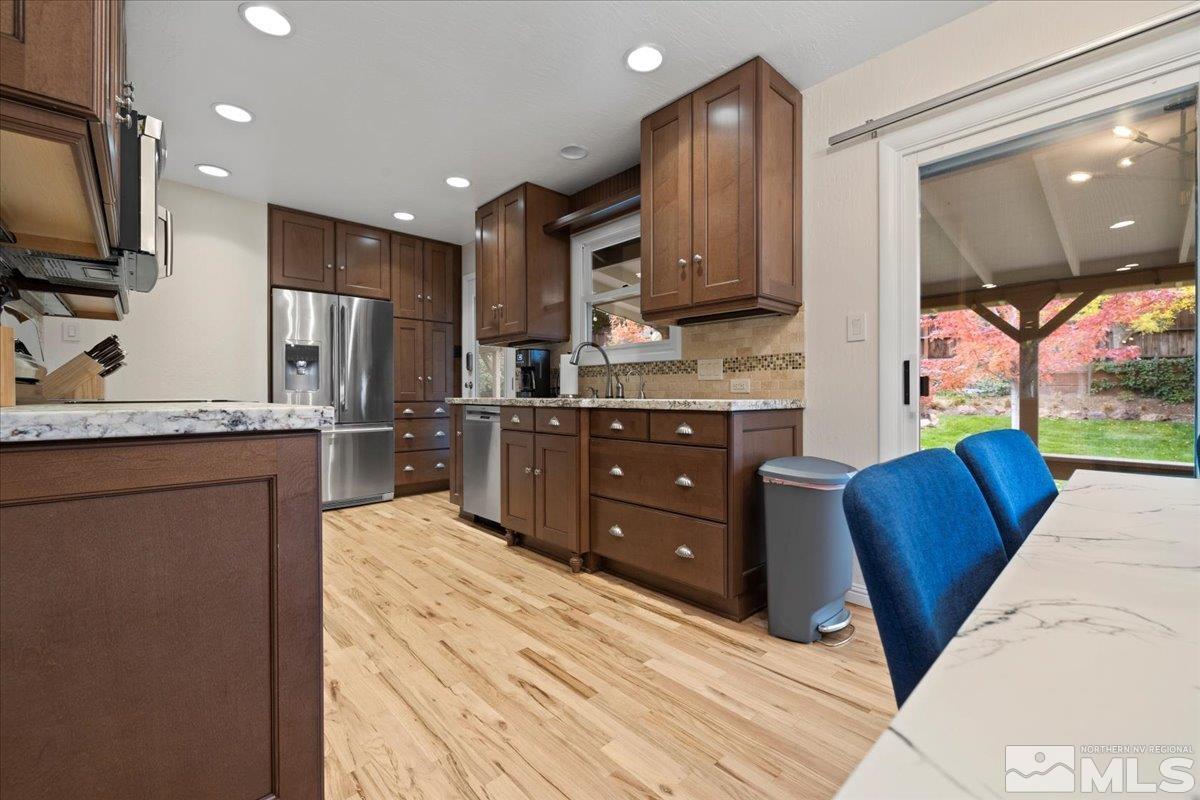 1420 Elizabeth Street Reno, NV 89509 - Photo 9 of 23 a kitchen with stainless steel appliances granite countertop a sink refrigerator and cabinets