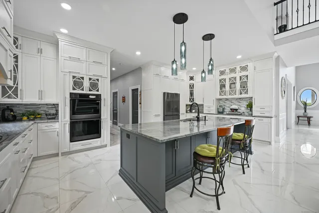 a kitchen with stainless steel appliances kitchen island granite countertop a table and chairs in it
