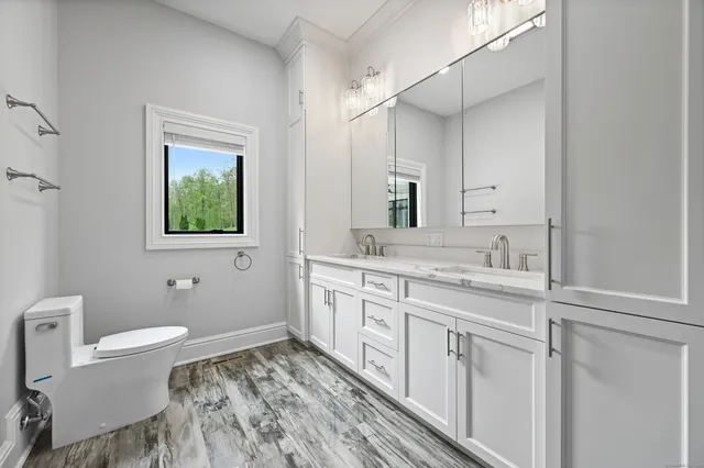 a spacious bathroom with a toilet sink and mirror