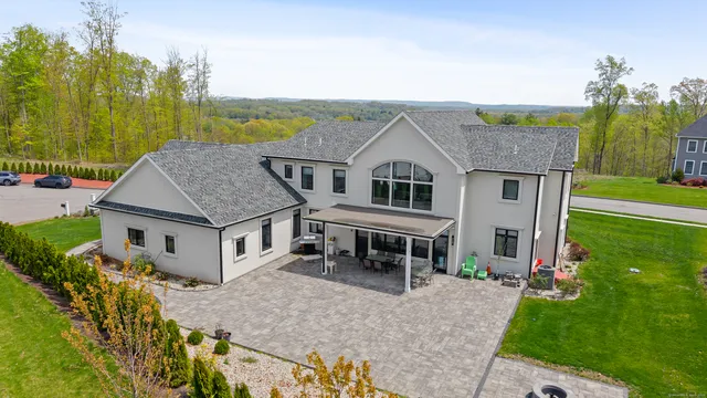 a aerial view of a house with table and chairs under an umbrella