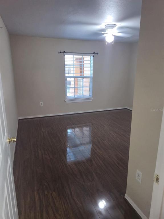 5459 Vineland Road, Unit 4310 Orlando, FL 32811 - Photo 8 of 12 wooden floor in an empty room with a window