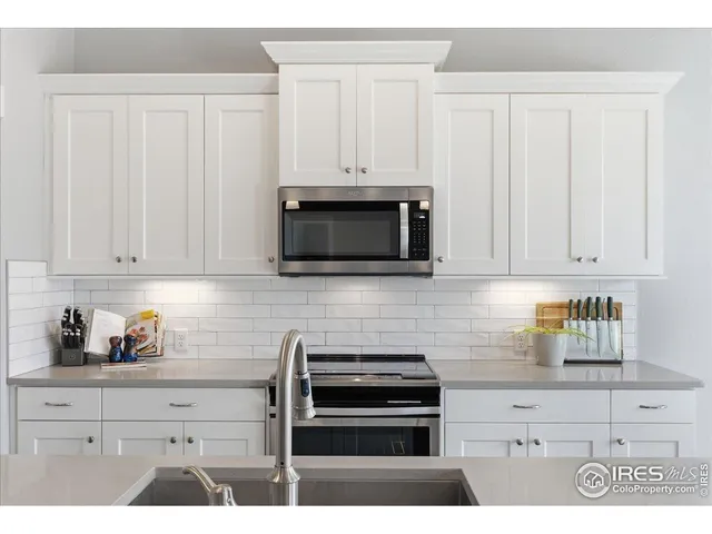 a kitchen with stainless steel appliances a stove a microwave and cabinets