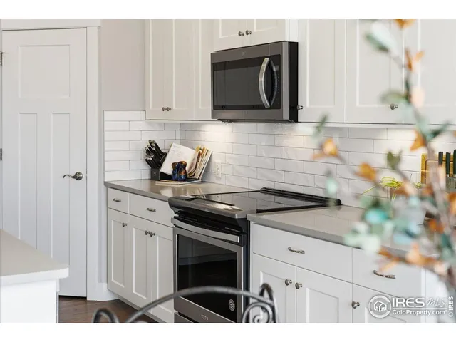 a kitchen with stainless steel appliances granite countertop white cabinets and stove