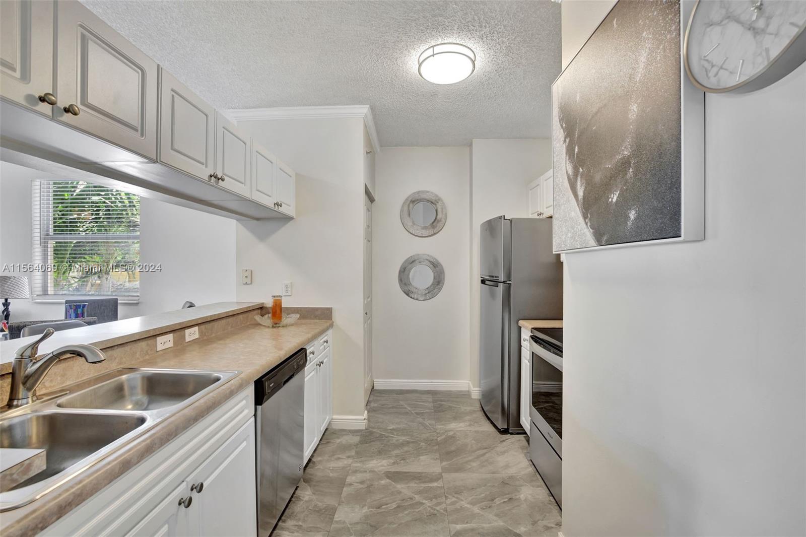 17150 North Bay Road, Unit 2216 Sunny Isles Beach, FL 33160 - Photo 13 of 46 a kitchen with a sink a stove and a refrigerator