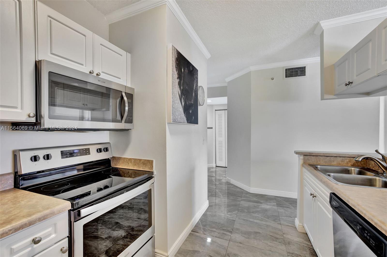 17150 North Bay Road, Unit 2216 Sunny Isles Beach, FL 33160 - Photo 18 of 46 a kitchen with stainless steel appliances a stove a microwave and a refrigerator