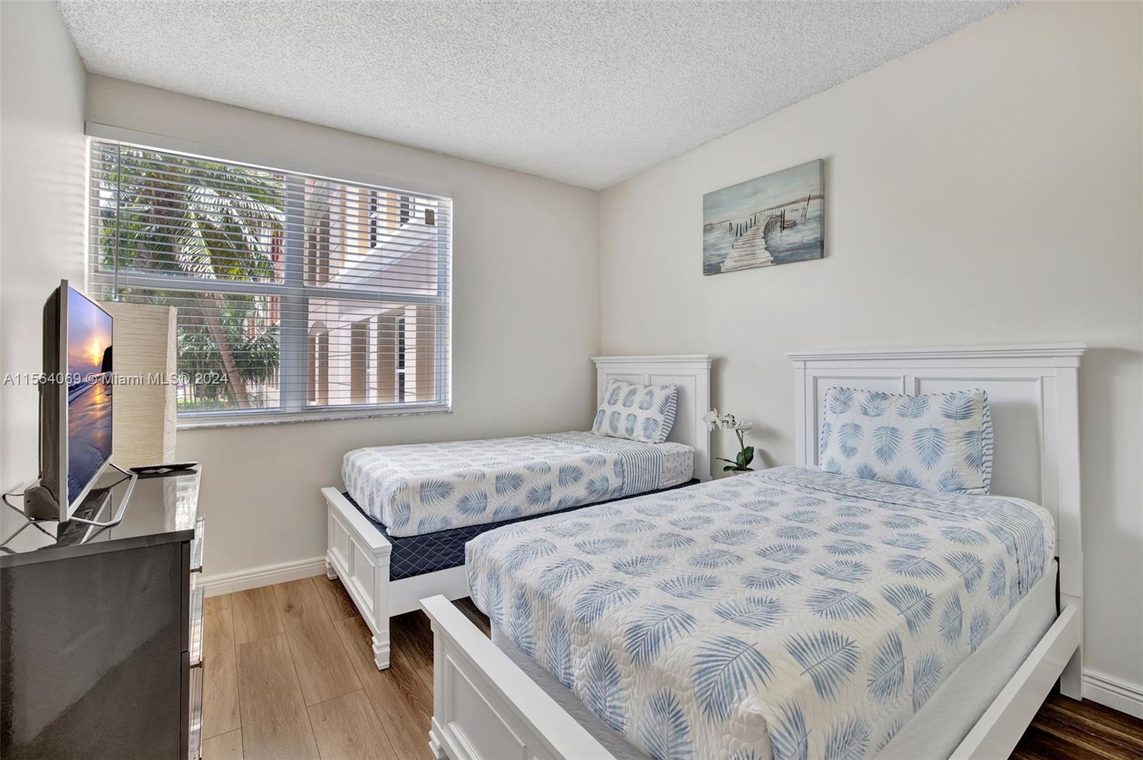17150 North Bay Road, Unit 2216 Sunny Isles Beach, FL 33160 - Photo 27 of 46 a bedroom with two beds and a large window