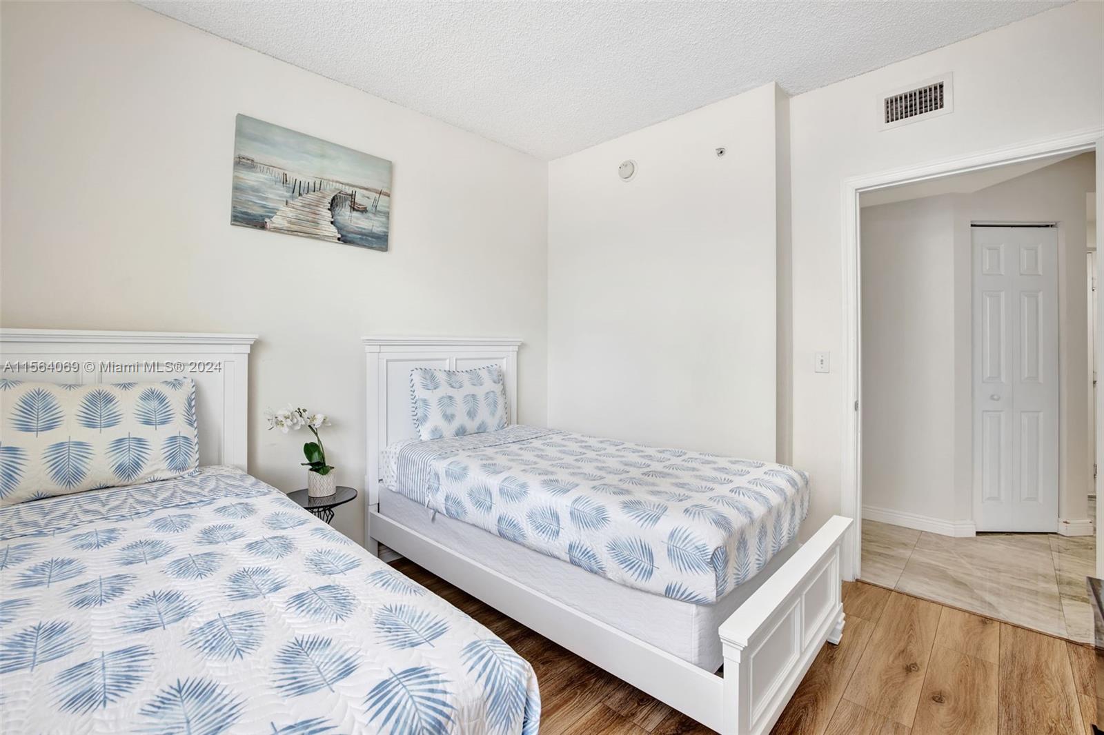 17150 North Bay Road, Unit 2216 Sunny Isles Beach, FL 33160 - Photo 29 of 46 a bedroom with a large bed and a wooden floor