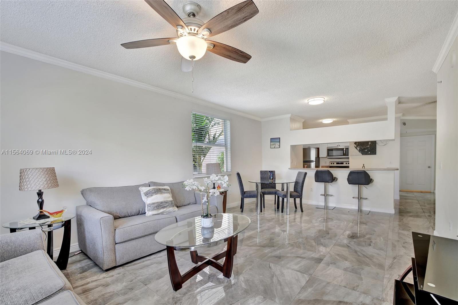 17150 North Bay Road, Unit 2216 Sunny Isles Beach, FL 33160 - Photo 6 of 46 a living room with lots of furniture and a chandelier