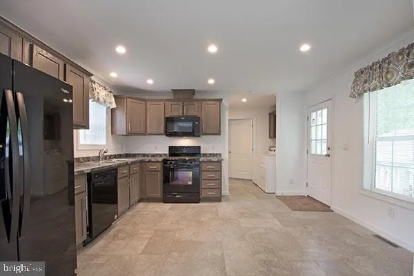 a kitchen with stainless steel appliances granite countertop a refrigerator oven stove a sink and a granite countertops