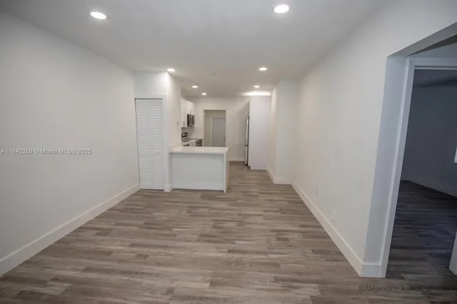 a view of a hallway with a sink and wooden floor