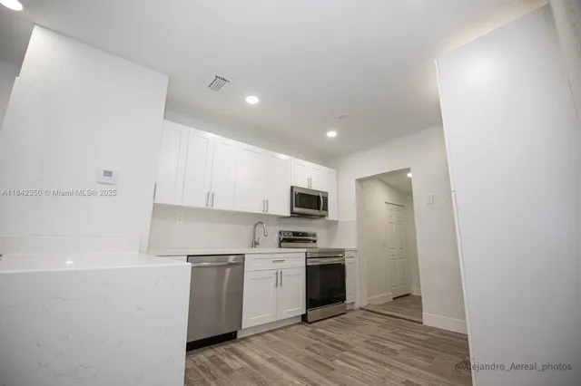a kitchen with a sink a refrigerator and a oven