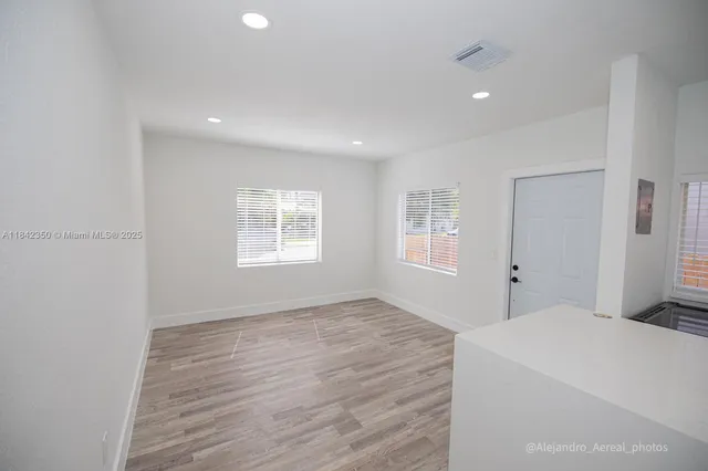 a big room with wooden floor and windows